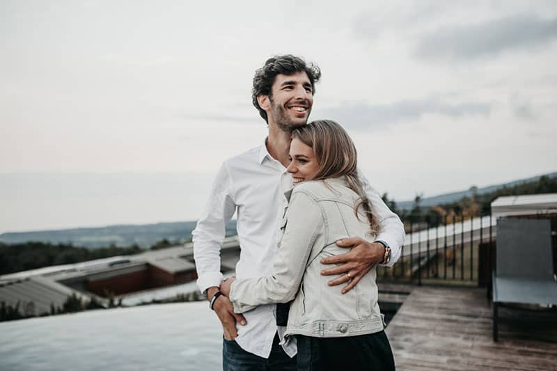 man hugging smiling woman