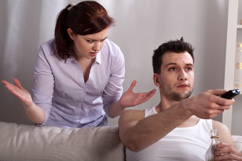 man ignoring woman while watching tv