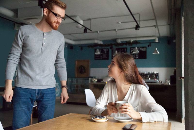 man talking to woman while she sitting