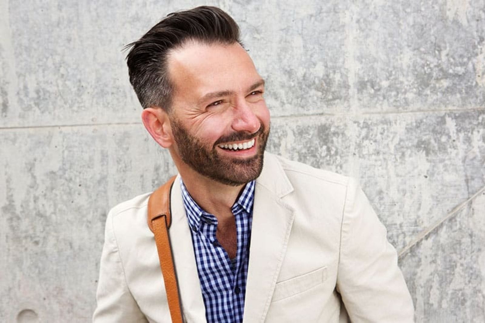 hombre de mediana edad sonriendo con ropa elegante