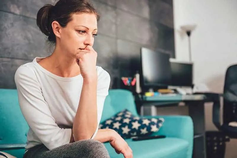 mindful worried woman sitting on the couch