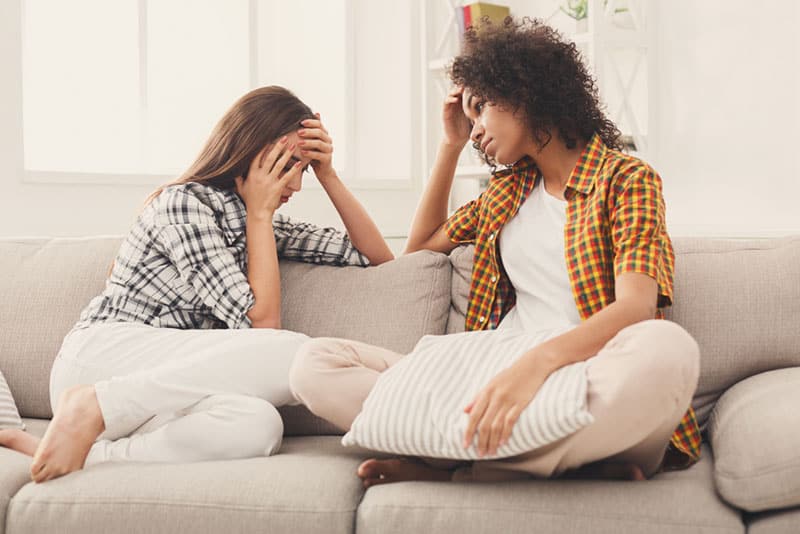 sad friends talking in the living room