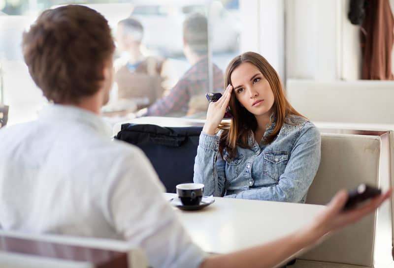 sad woman listening to man in cafe