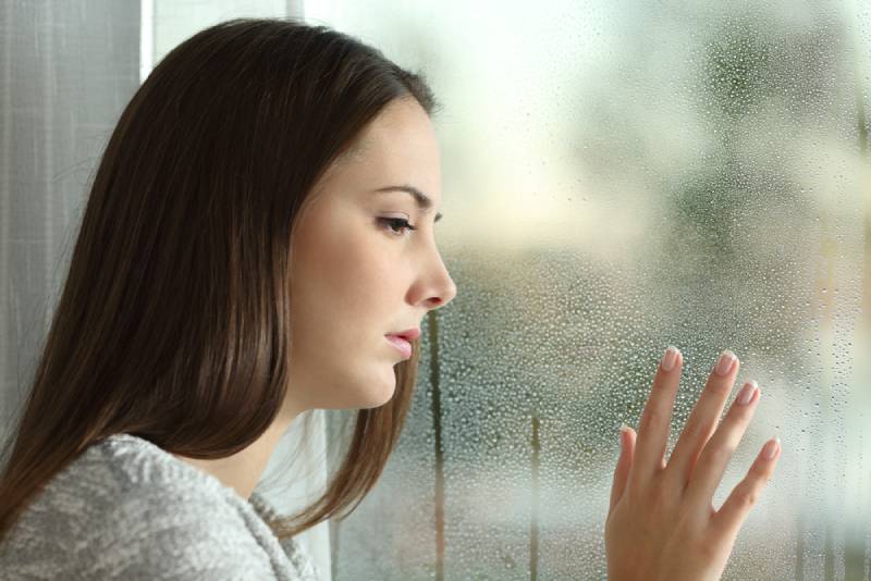 sad woman looking outside
