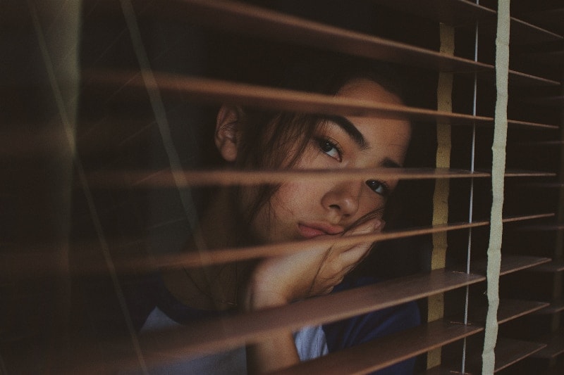 sad woman looking through the window