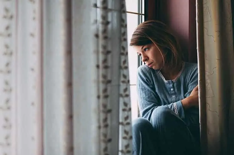 sad woman looking through the window