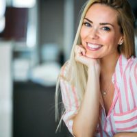 Retrato de uma mulher sorridente, bonita, jovem e feliz, com cabelo comprido