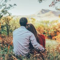 sweet couple sitting in grass in the nature