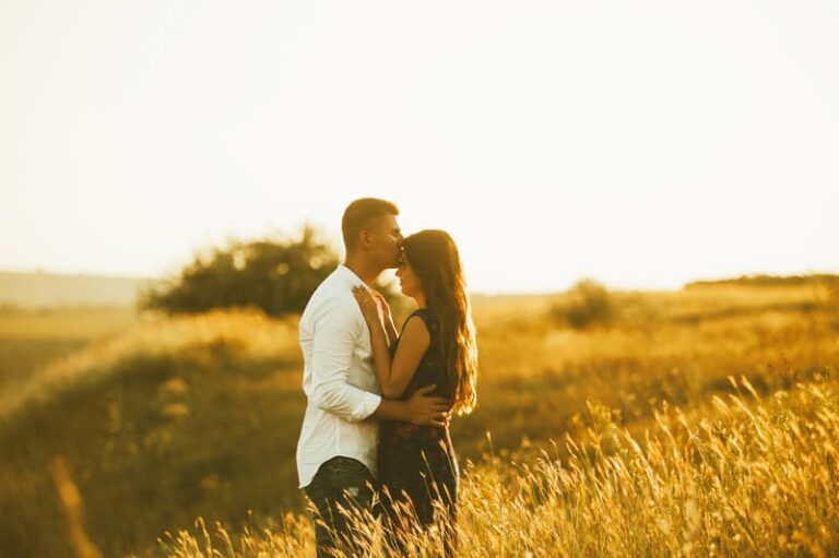 Young couple inlove on a field at sunset