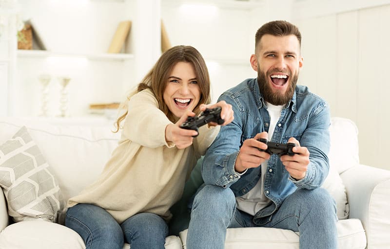 Fãs da Xbox. Casal maluco se divertindo jogando videogame no Playstation, descansando em casa