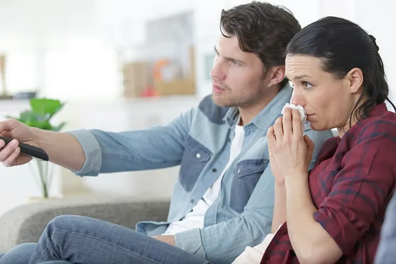 young couple watching sad movie woman cry