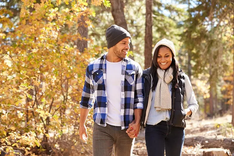 African American Couple Walking Through Fall Woodland