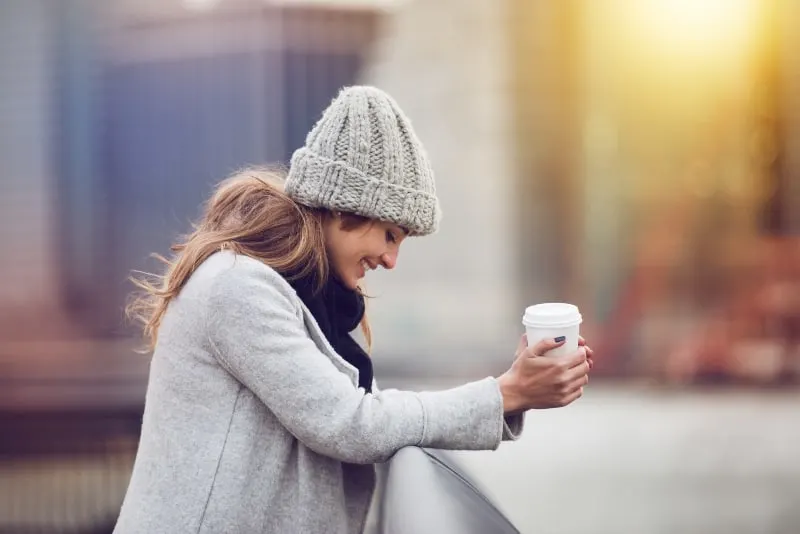 Beautiful happy young adult woman drinking coffee 