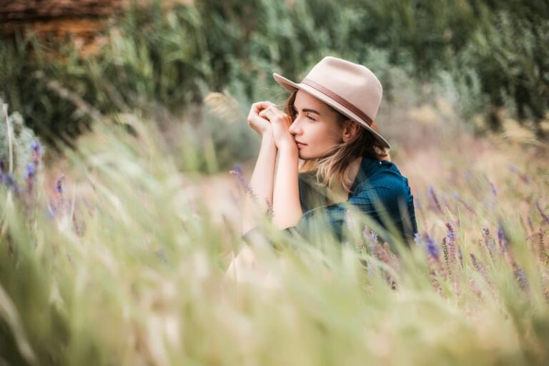 Summer portrait of young hipster woman sitting in a grass