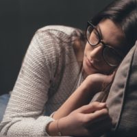 woman with glasses sitting on sofa