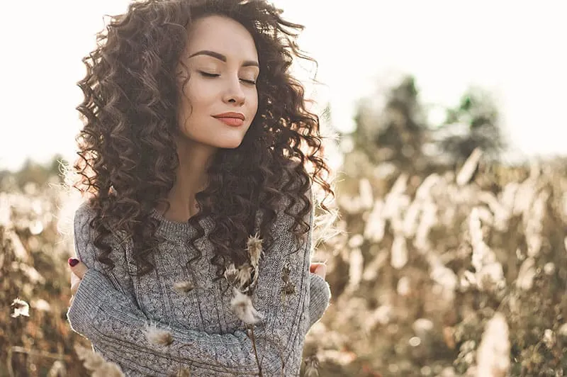 Outdoor atmospheric lifestyle photo of young beautiful lady. Brown hair and eyes. Warm fall. Autumn vibes. Softness, warmth and comfort