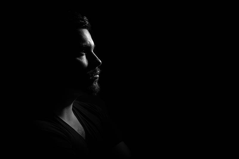 side view of man with black background