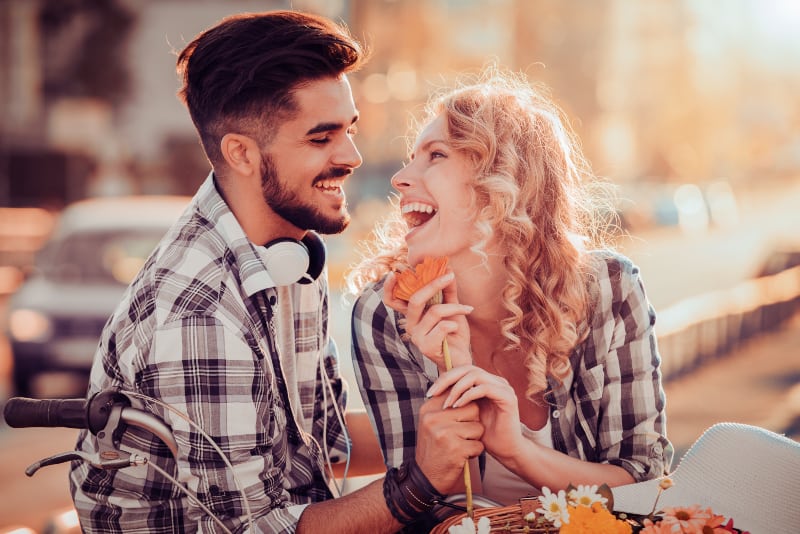 smiling couple wearing shirt looking each other outside