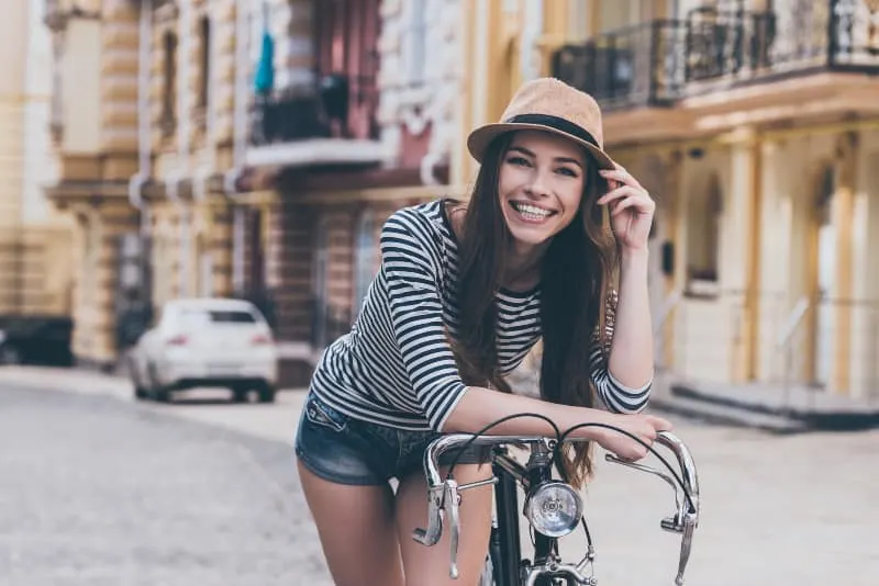 smiling woman on bicycle outside