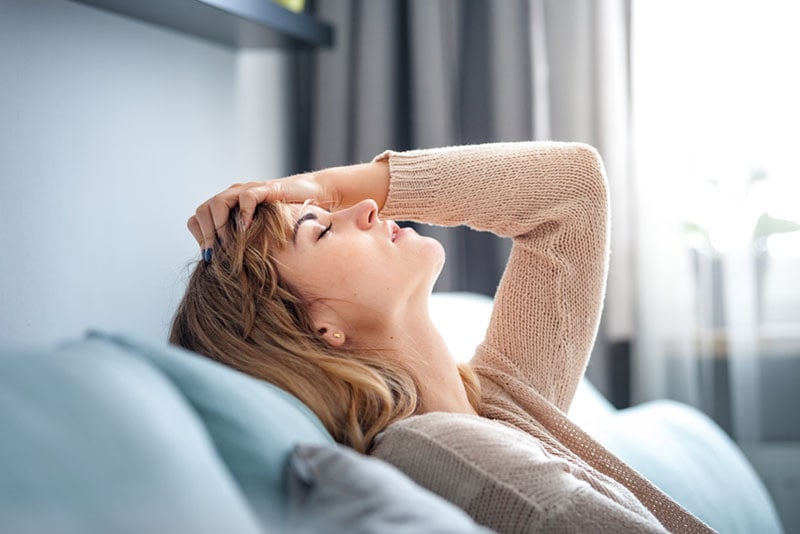 mujer cansada sentada en el sofá