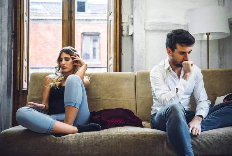 upset couple sitting in living room
