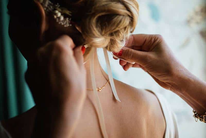 woman helping bride with hair