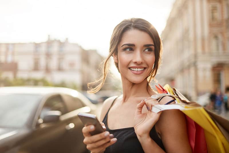 mujer con bolsas de la compra en la calle