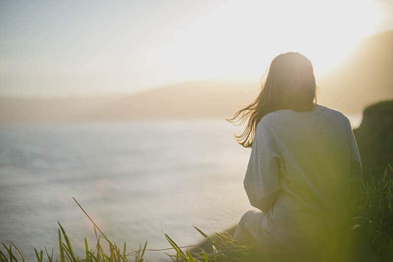 woman sitting beside water