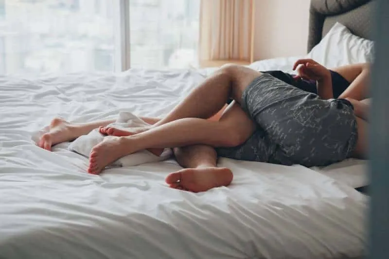 young sexy couple in love lying in bed in hotel