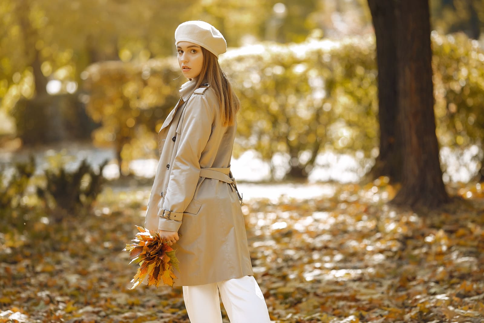 giovane donna con foglie in mano nel parco