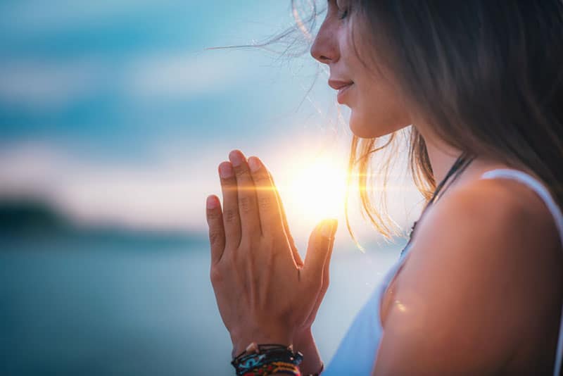 mulher jovem a meditar de olhos fechados