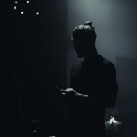 silhouette of man typing on his phone in dark