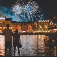 back view of man and woman looking fireworks