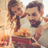 the girl hands a gift to the surprised guy