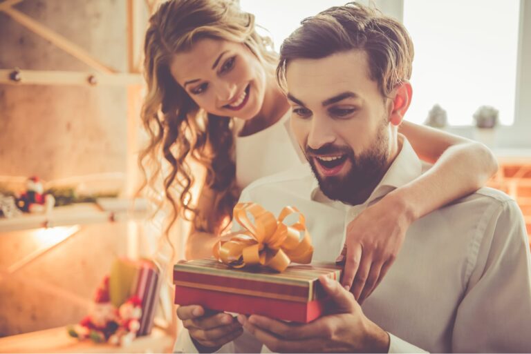 the girl hands a gift to the surprised guy