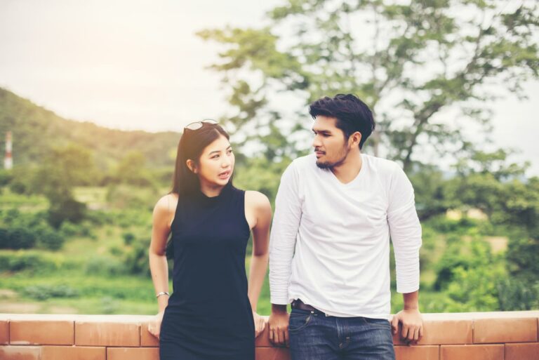 casal em pé no exterior a conversar