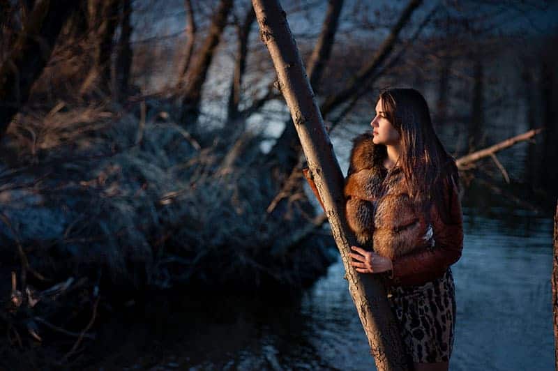 woman leaning on tree