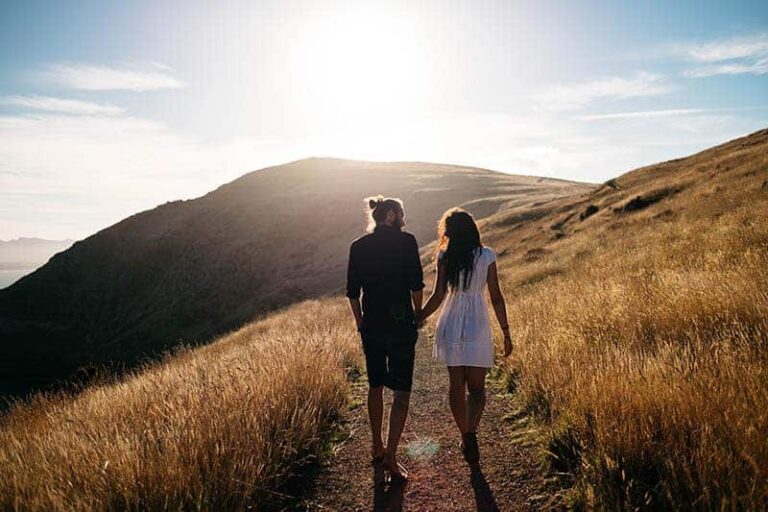 couple holding hands and walking in nature