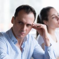 worried man turning head away from woman