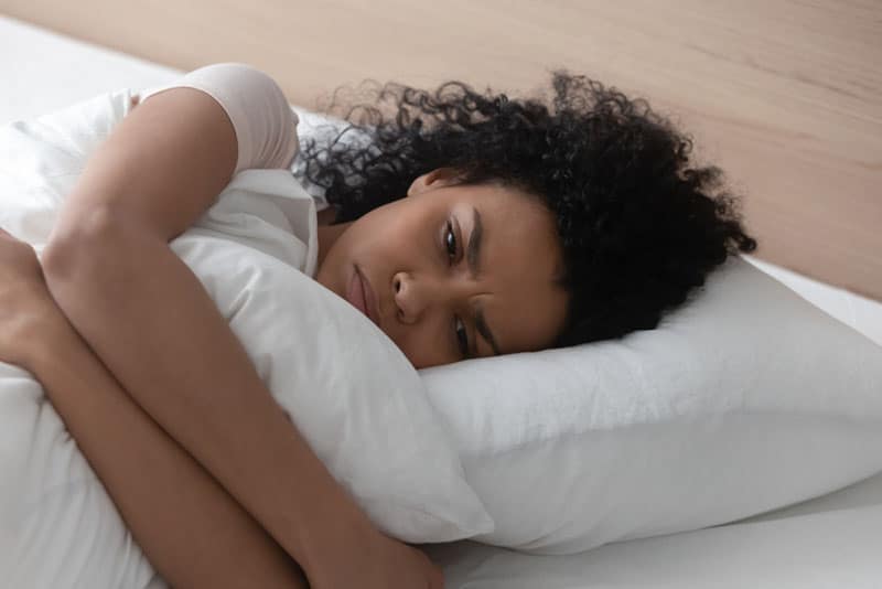 sad woman lying in bed
