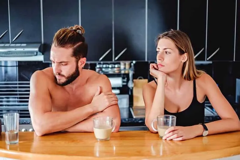 Couple not talking to each other while sitting in the kitchen