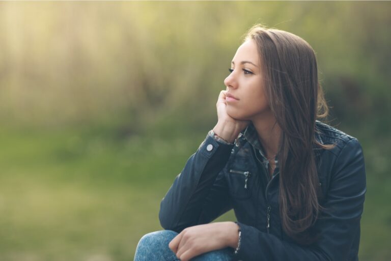 thoughtful woman sitting outside