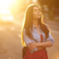 young woman standing in sunlight