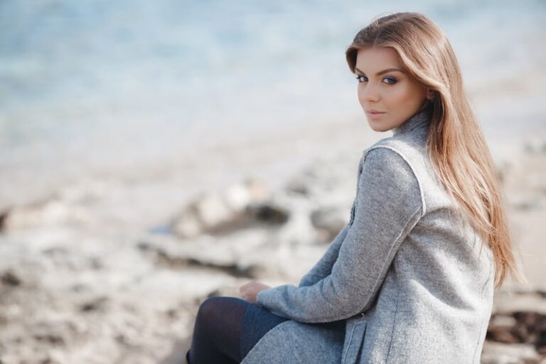 beautiful young woman wearing jacket and sitting outside