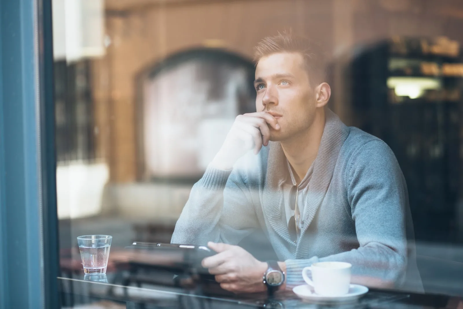 Pensive young man using tablet