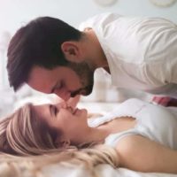 pareja besandose en la cama