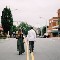 man and woman walking on main road