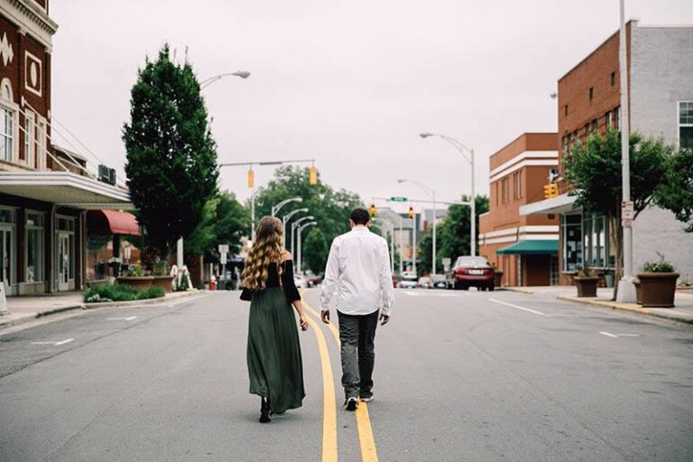 man and woman walking on main road
