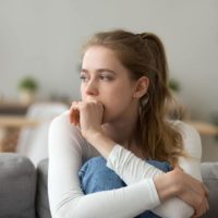 worried young woman biting her hand