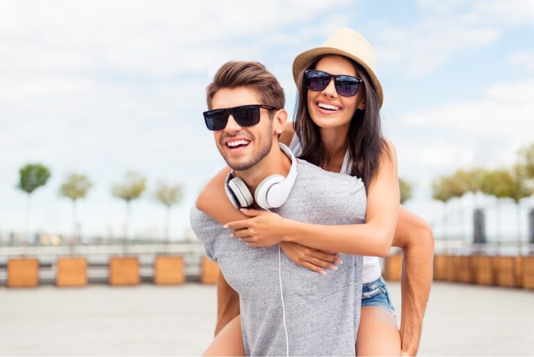 Handsome man carring his smiling girlfriend on back.